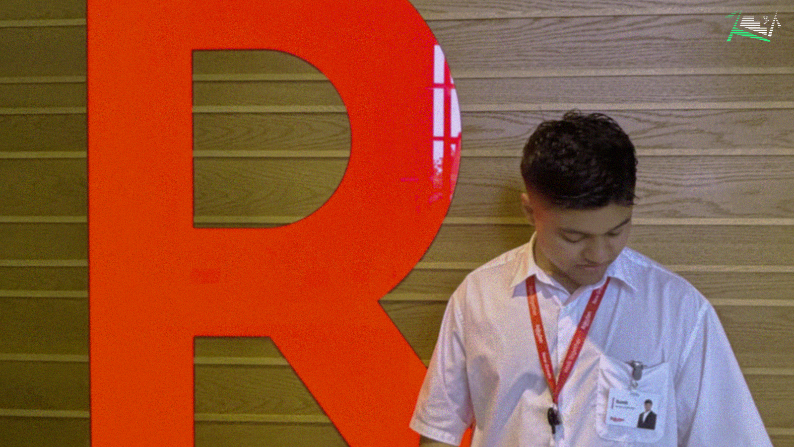 A photo of me looking downwards in front of the Rakuten logo